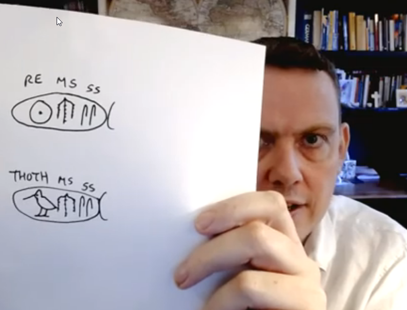 Stephen Davies holding up hieroglyphs from the Rosetta Stone
