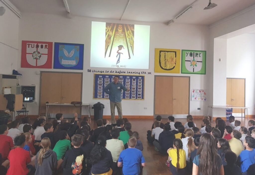 Stephen Davies presenting to a class of Key Stage 2 children in a hall