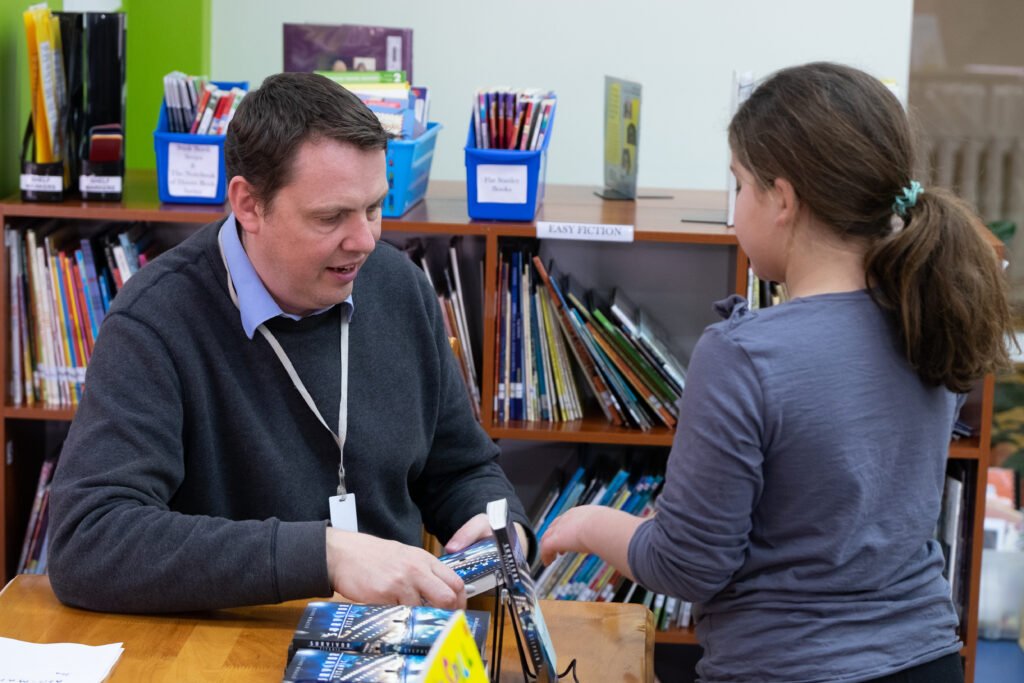 Stephen Davies signing a book for a Yera 4 girl