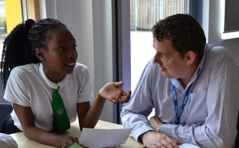 Stephen Davies talking to a Year 6 student in a writing workshop