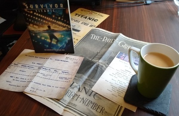 Titanic memorabilia on a desk next to a cup of tea