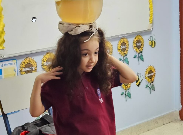 a girl balancing a bowl on her head